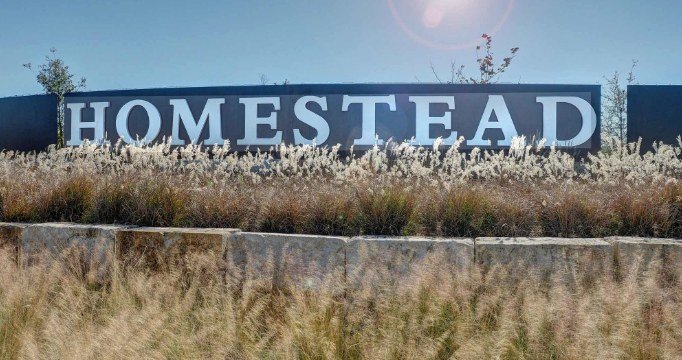 Homestead community entrance sign representing off-grid solar-powered living